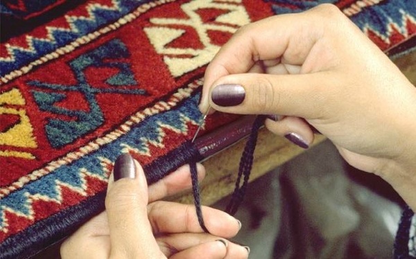 The binding that finishes the rugs on the sides is being rewrapped by hand using beautiful new Persian wool