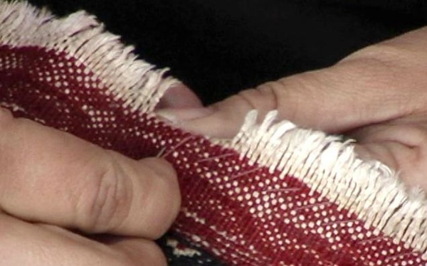 The worn areas are unraveled until the ends are even off. Then a continuous overcasting stitch is hand sewn into the end of the rug to stabilize and stop further unraveling