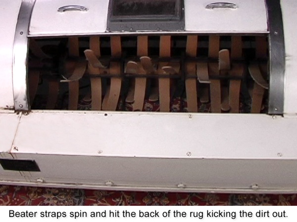 Beater straps spin and hit the back of the rug, kicking the dirt out.